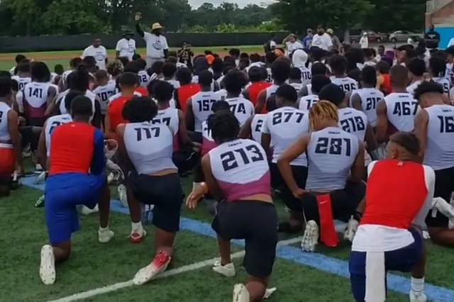 Hundreds of high school athletes kneeling in numbered jerseys at a recruiting camp