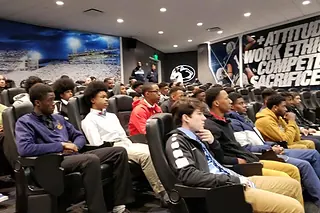 Next Level and Beyond students seated in a college team room during an official visit