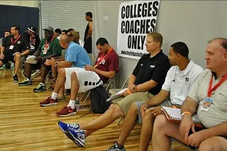 College coaches seated in an evaluation room marked colleges coaches only