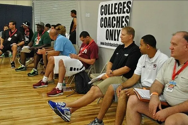 College coaches seated in an evaluation room marked colleges coaches only