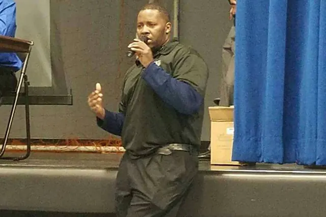 Speaking with a microphone at a Keys to the Journey assembly