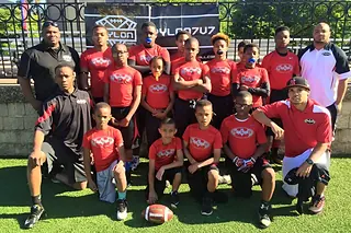 Next Level and Beyond youth team in red jerseys with their coaches at a Pylon 7v7 event