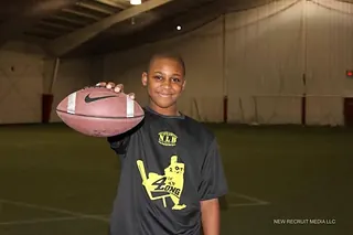 Jamari Johnson as a young athlete holding a football at a Next Level and Beyond session