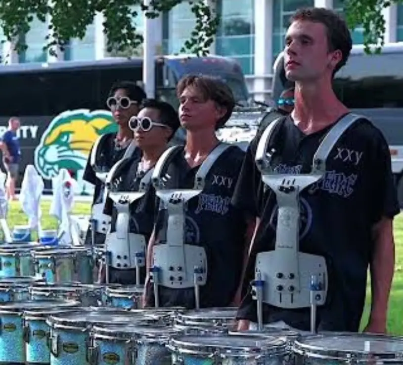 High school drumline percussionists in uniform performing
