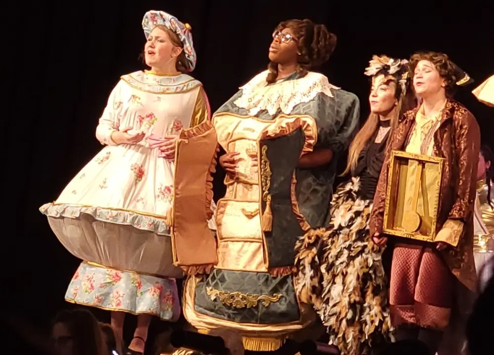 Students in costume performing in a stage theater production